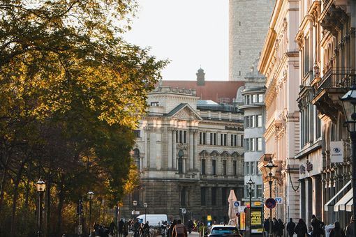 Das Foto zeigt einen Blick in eine Straße zwischen großen und alten Gebäuden. 