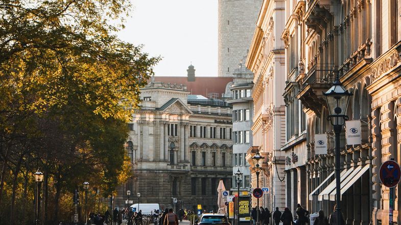 Das Foto zeigt einen Blick in eine Straße zwischen großen und alten Gebäuden. 